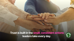 Hands in a huddle with the text 'trust is built in the small, consistent actions leaders take every day'